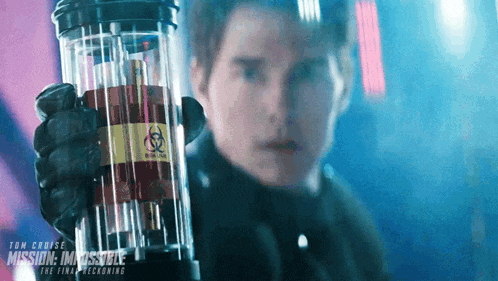 a man holding a container that says mission impossible on the bottom
