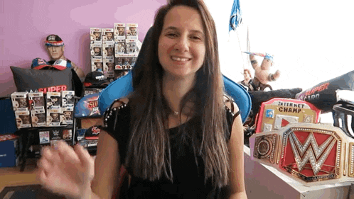 a woman is standing in front of a collection of wwe memorabilia