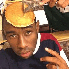 a man is holding a pancakes on top of his head .