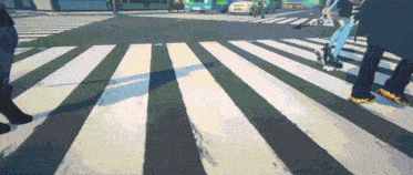 a group of people crossing a zebra crossing in a city