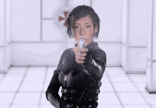 a woman holding a gun in front of a sign that says umbrella corp