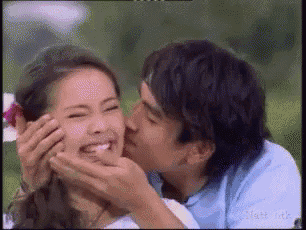 a man is kissing a woman on the cheek while she laughs
