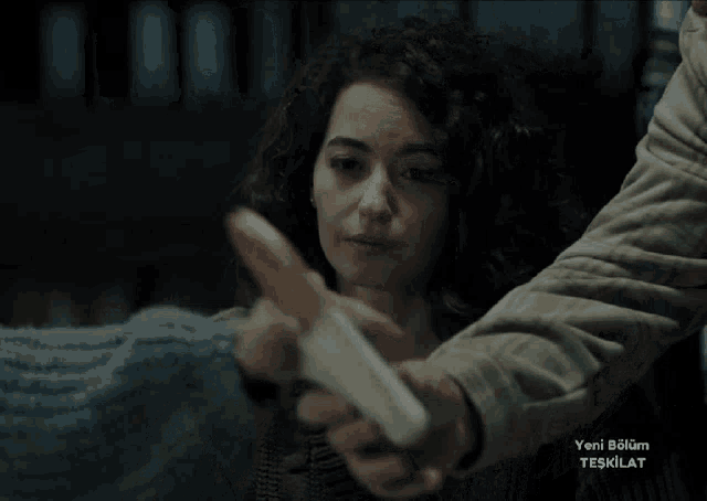 a woman with curly hair is being held by a man in a video that says yeni bölüm teşkilat