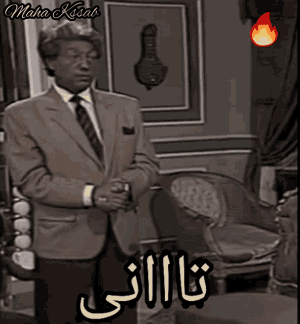 a man in a suit and tie is standing in a room with maha kissab written on the bottom right
