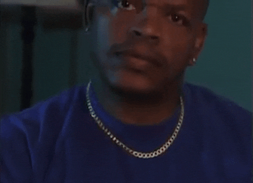 a man in a blue shirt is looking at the camera with the words " doebatsja " written above him