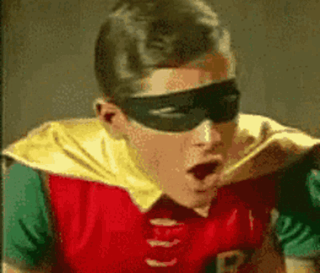 a man in a robin costume is making a funny face .