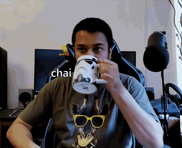 a man drinking from a storm trooper mug with chai written on the bottom
