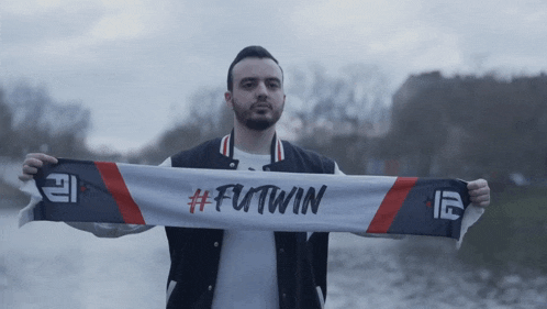 a man holding a scarf that says futwin