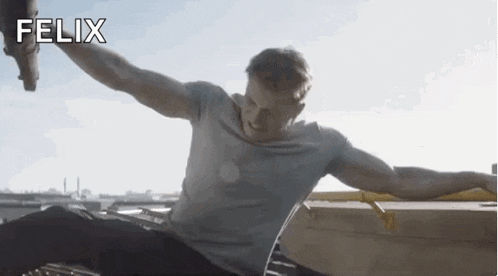 a man is sitting on a roof with his arms outstretched and the name felix is on the bottom
