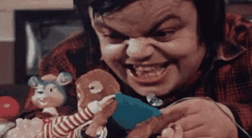 a man in a plaid shirt is holding a stuffed animal and smiling .