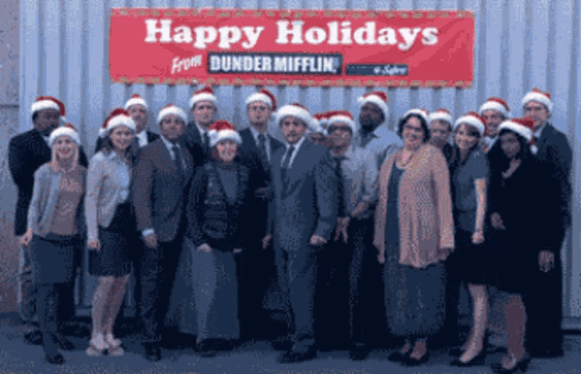 a group of people standing in front of a sign that says happy holidays