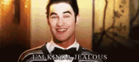 a man in a tuxedo is smiling with the words `` i 'm kinda jealous '' above him .