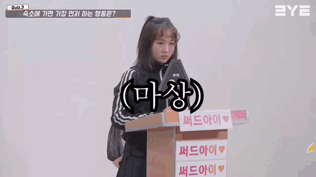a girl stands at a podium with a sign that says eye on it