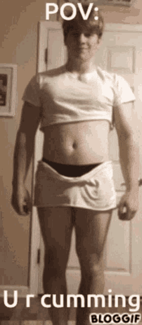 a man wearing a crop top and shorts is standing in front of a door ..