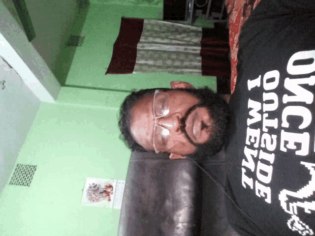 a man wearing glasses and a black shirt that says once inside i never go