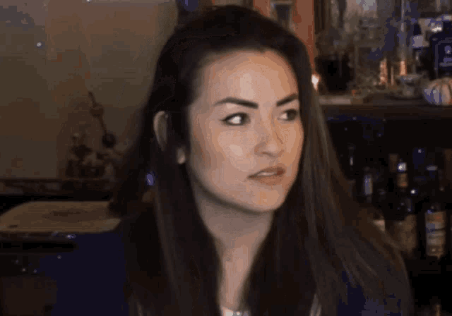 a woman in a blue shirt is looking at something