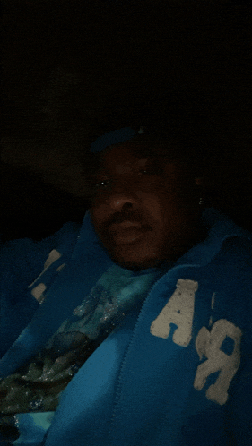 a man is wearing a blue jacket with the letter a on the sleeve