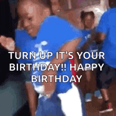 a boy in a blue shirt is dancing in front of a crowd of people .