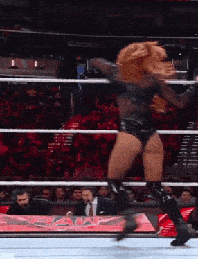a woman in a wrestling ring with the word raw on the side