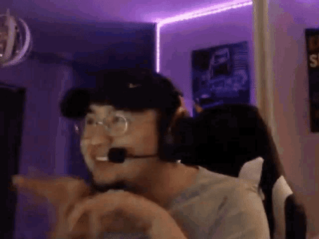 a man wearing glasses and headphones is sitting in a chair .