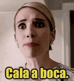 a woman is making a funny face with the words cala a boca written on her face .