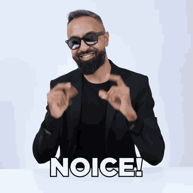 a man with a beard wearing sunglasses and a black jacket says " noice "