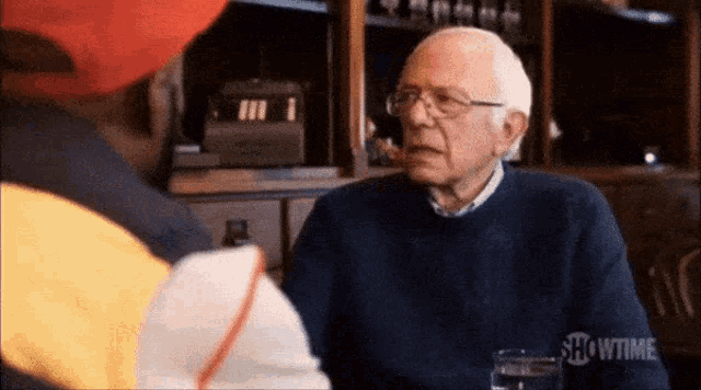 a man in a blue sweater is talking to another man with showtime written on the bottom