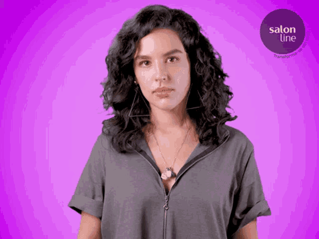 a woman with curly hair is standing in front of a purple background that says salon line