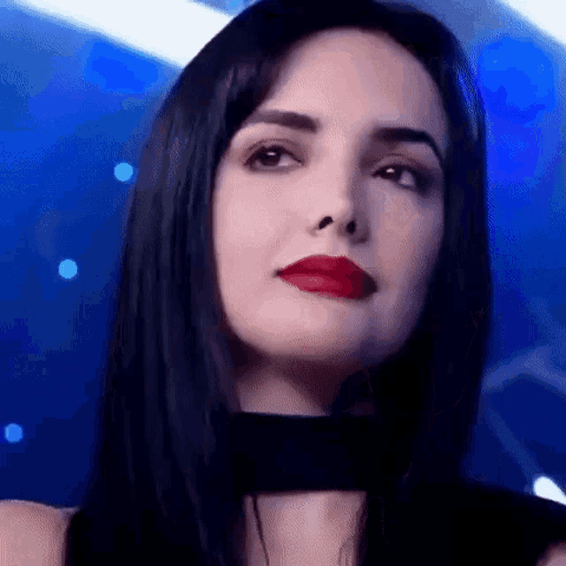 a close up of a woman 's face with red lipstick and a choker .