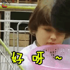 a girl is holding a pink basket with chinese writing on it ..