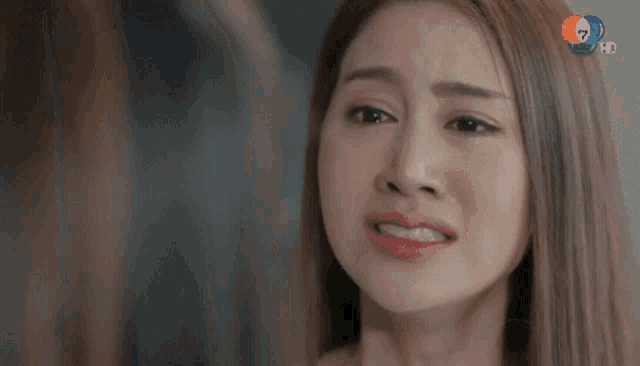 a woman is crying with a tear running down her cheek .