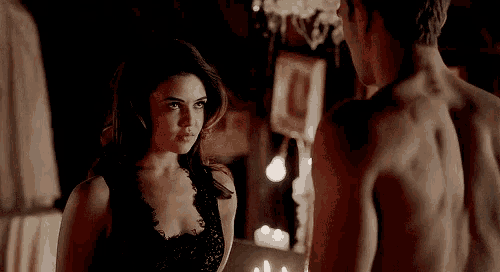 a man and a woman are standing next to each other in a dark room .