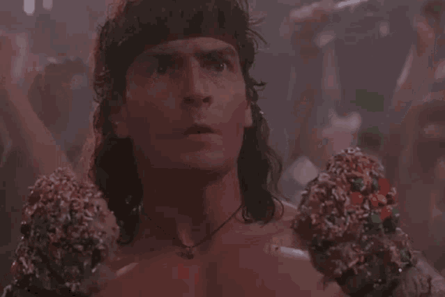 a man with a mullet is holding a pair of boxing gloves covered in sprinkles .