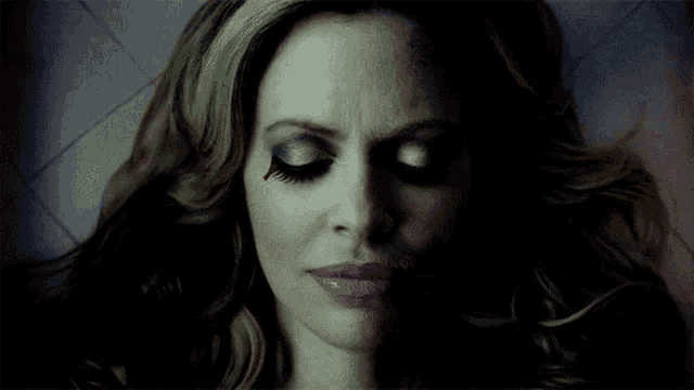 a close up of a woman 's face with a tear in her eye