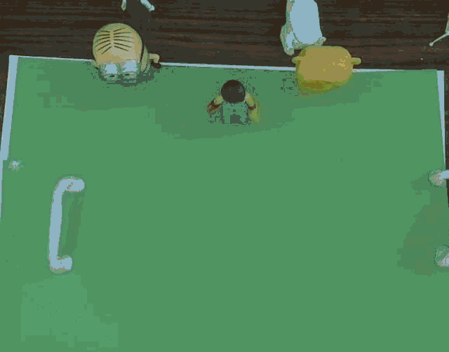a soccer game is being played on a green field with a yellow ball
