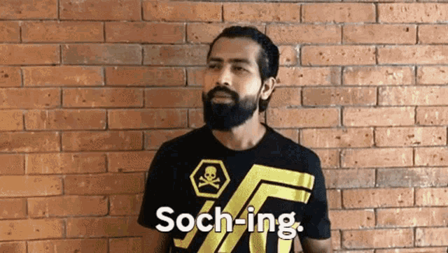 a man with a beard wearing a black shirt with the word soch-ing on it