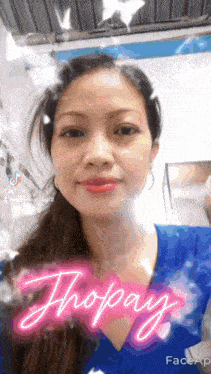 a woman is wearing a blue shirt with the word thopay written on it .