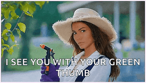 a woman wearing a hat and gloves is holding a garden hose and says " i see you with your green thumb "