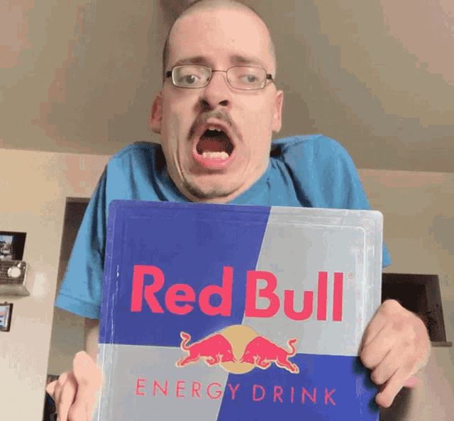 a man holding a red bull energy drink