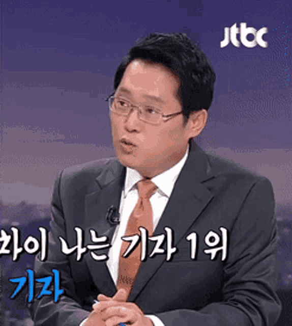 a man in a suit and tie is talking in a foreign language