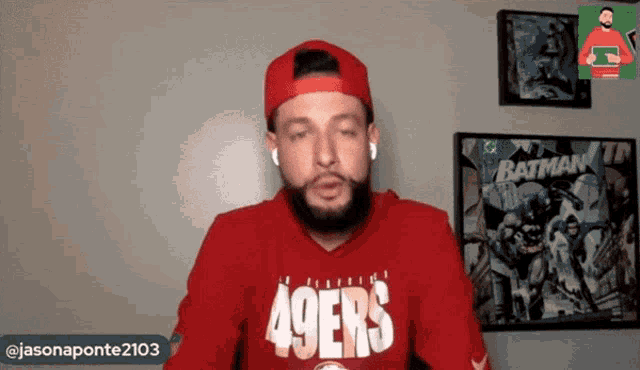 a man wearing a red 49ers hoodie talks on a video call