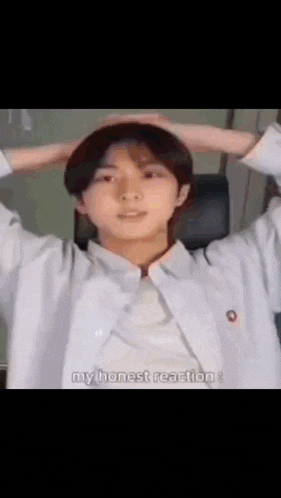 a young man with his hands on his head is making a funny face and says `` my honest reaction '' .