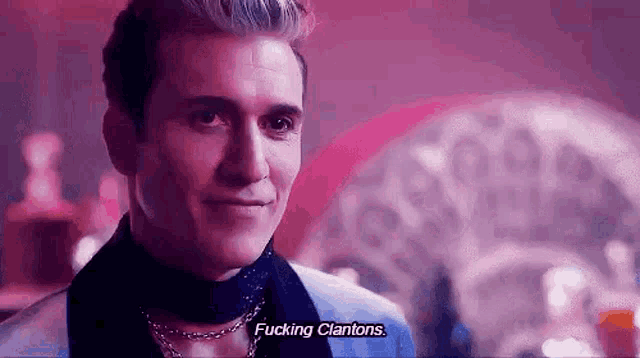 a man in a suit and choker is talking to another man in a club .