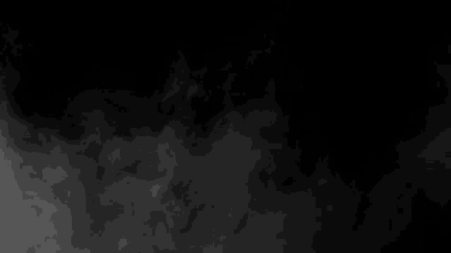 smoke is moving in the air on a black background in slow motion .