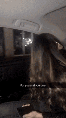 a woman sitting in the back seat of a car with the words for you and you only written on the screen