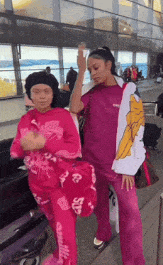 a woman in a pink outfit has the word supreme on her jacket