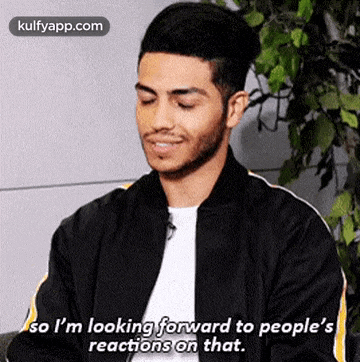 a man in a black jacket is smiling and saying `` so i 'm looking forward to people 's reactions on that ''