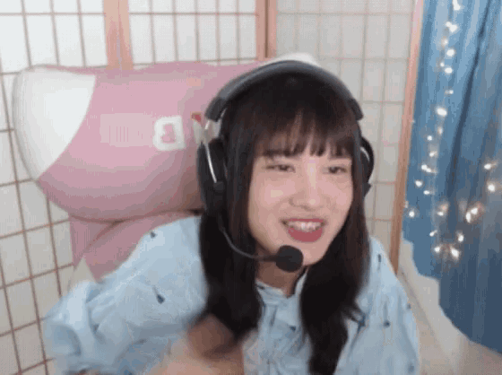 a girl wearing headphones and a microphone with the letter b on the back of her shirt