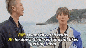 two young men are standing next to each other on a beach and one of them is talking about crabs .