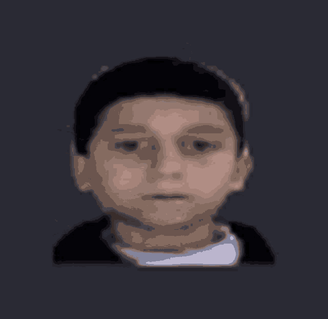 a close up of a young man 's face with a gray background .